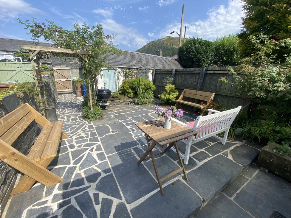 A garden with a table and benches at Swn Yr Afon in Abergynolwyn near Tywyn