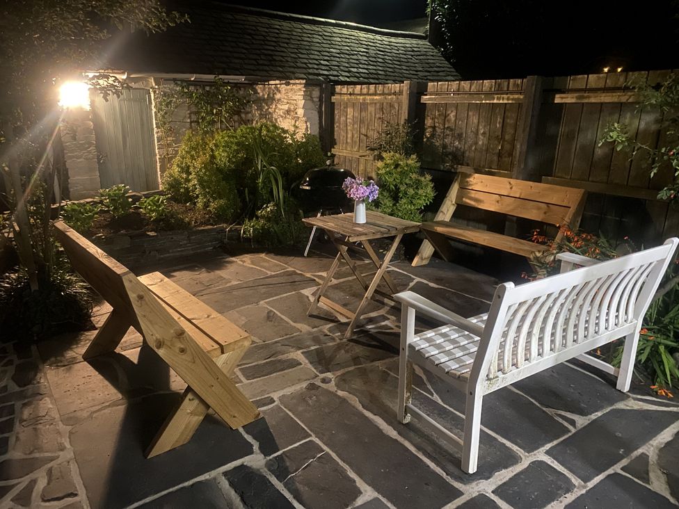 A garden with benches and a table at Swn Yr Afon Abergynolwyn near Tywyn
