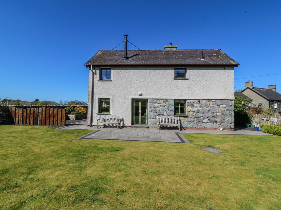 A house with a stone wall and garden at Bronfa Tregarth