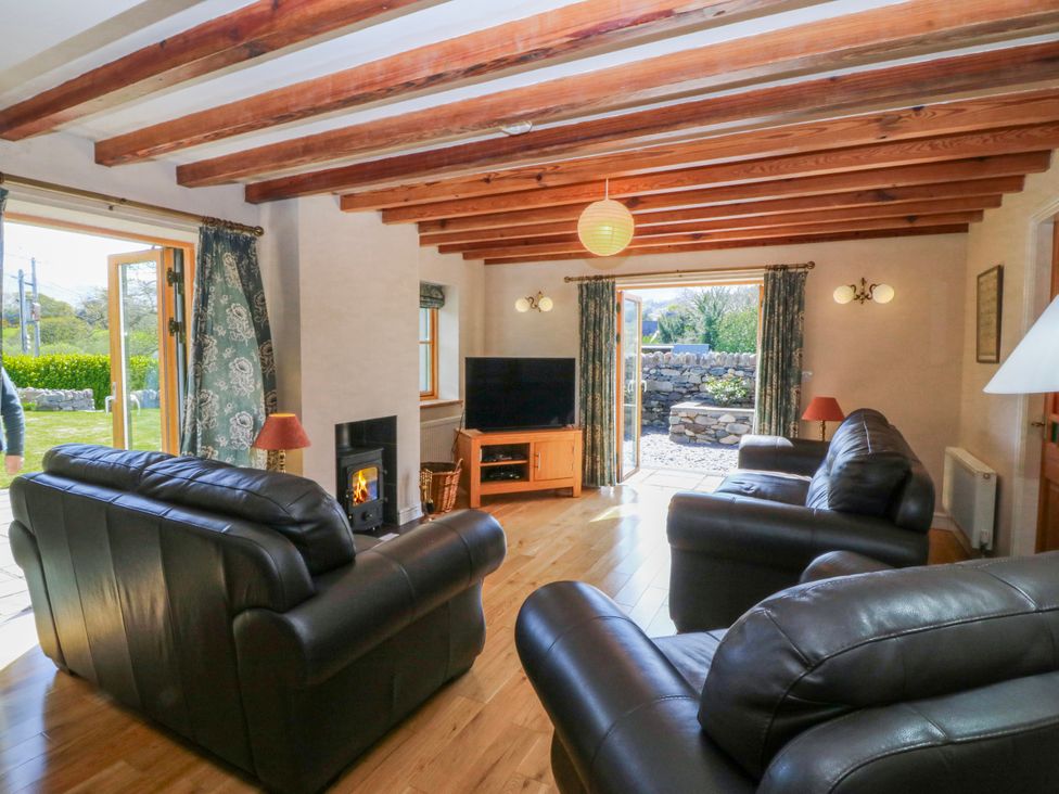 A living room with a television and sofas at Bronfa in Tregarth