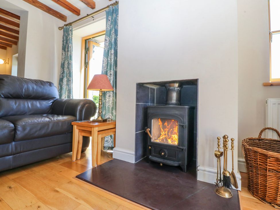 A living room with a sofa and a fireplace at Bronfa in Tregarth