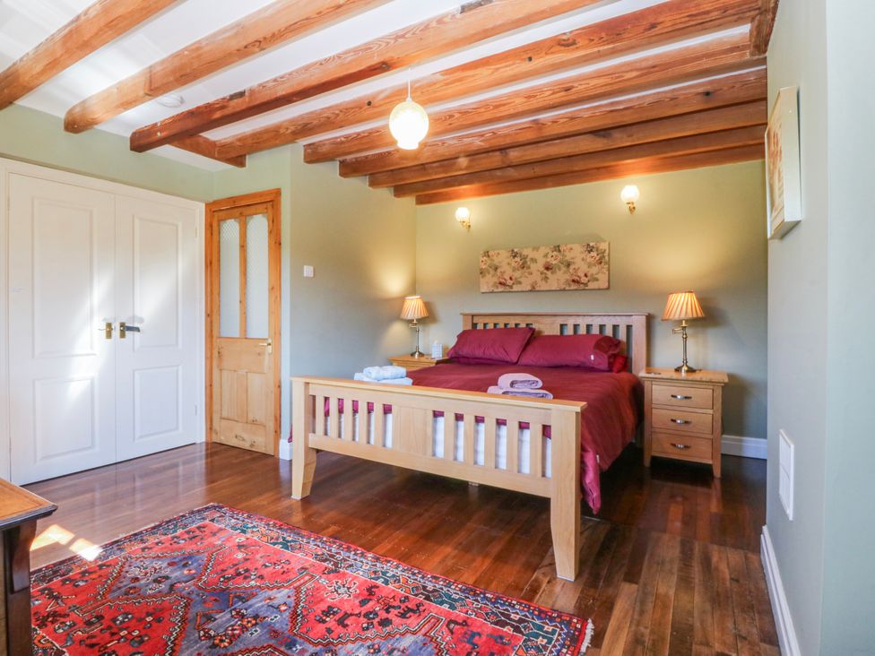 A bedroom with a bed and nightstands at Bronfa in Tregarth