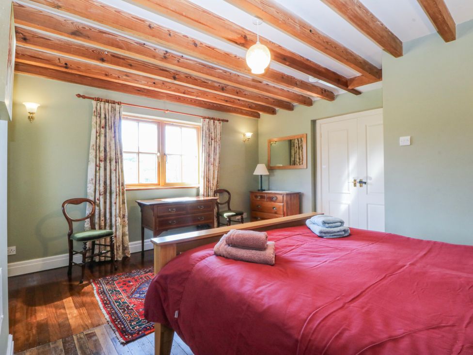 A bedroom with a bed and dresser at Bronfa in Tregarth