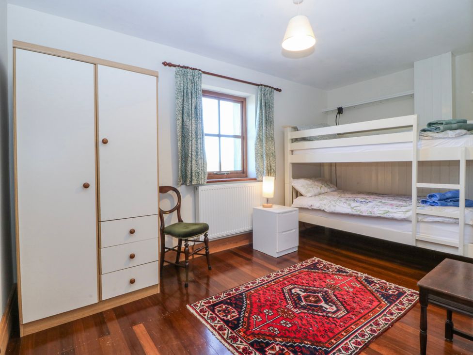 A bedroom with a bunk bed and wardrobe at Bronfa in Tregarth