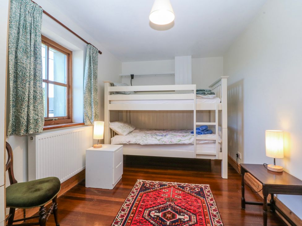 A bedroom with a bunk bed and a rug at Bronfa in Tregarth