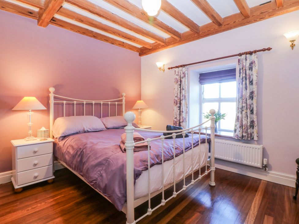 A bedroom with a bed and nightstand at Bronfa in Tregarth