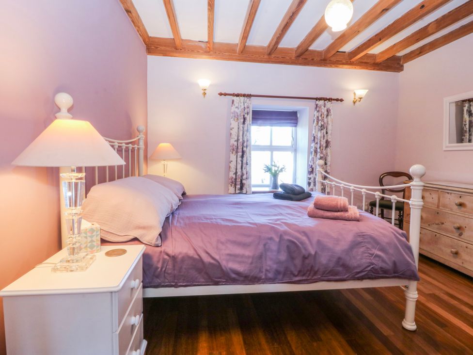 A bedroom with a bed and nightstand at Bronfa in Tregarth