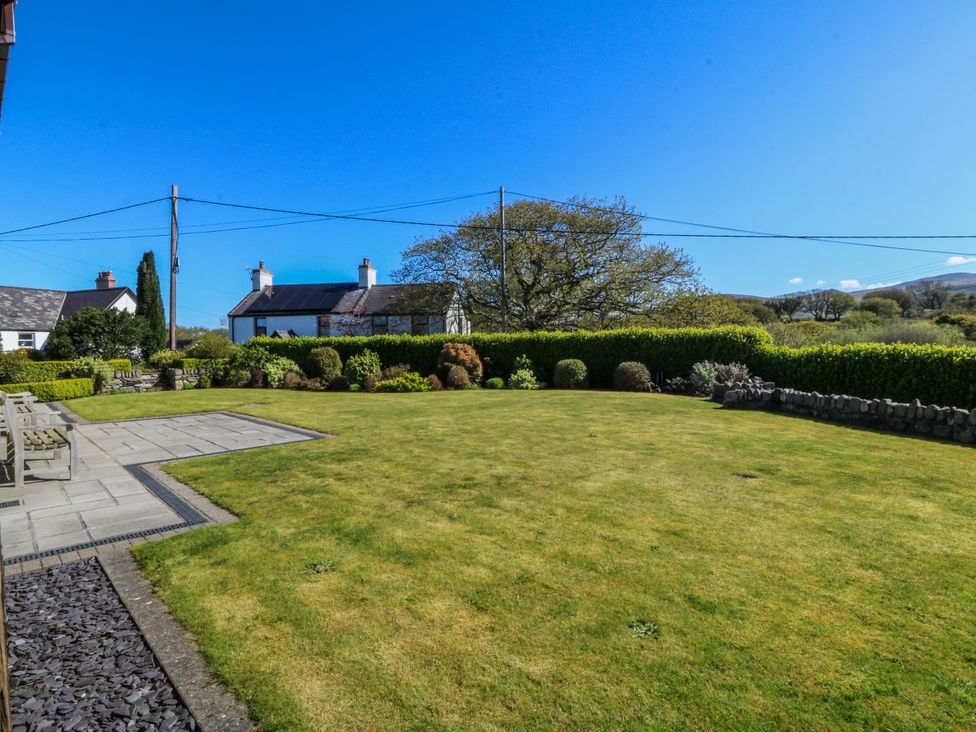 A garden area with a lawn and patio at Bronfa in Tregarth