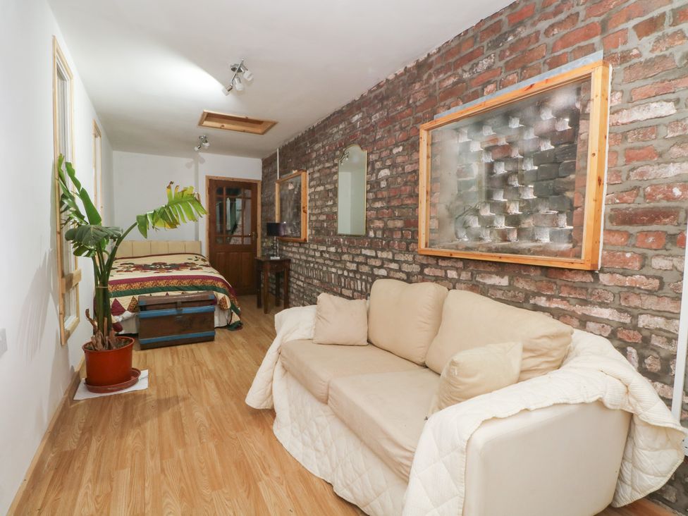 A bedroom with a sofa and bed at The Toolshed in Birchwood