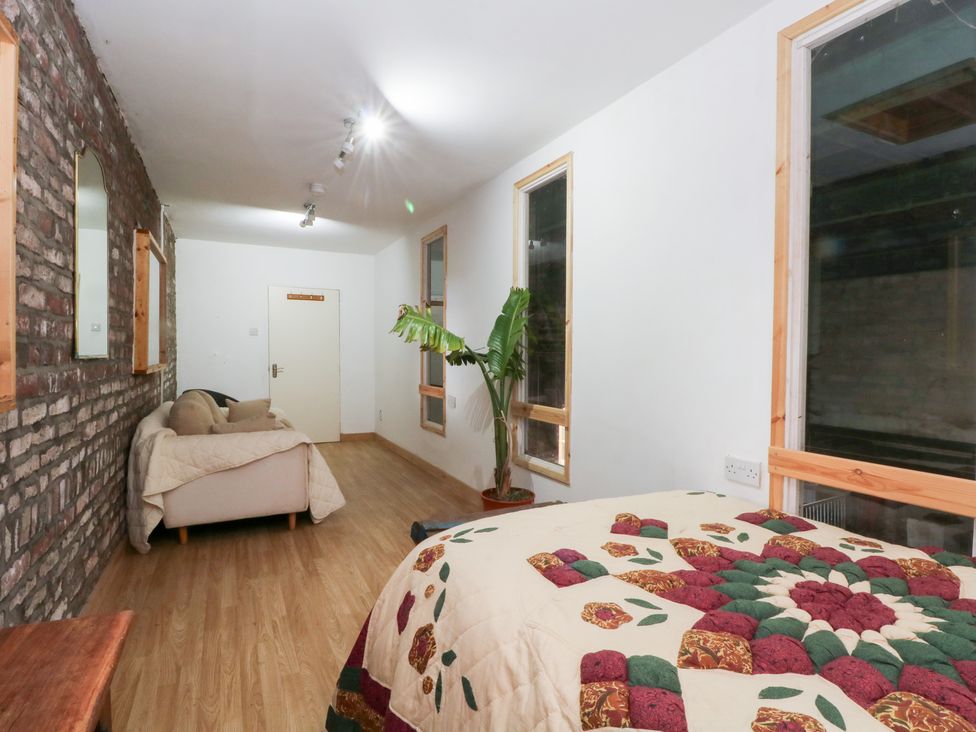 A bedroom with a bed and couch at The Toolshed in Birchwood