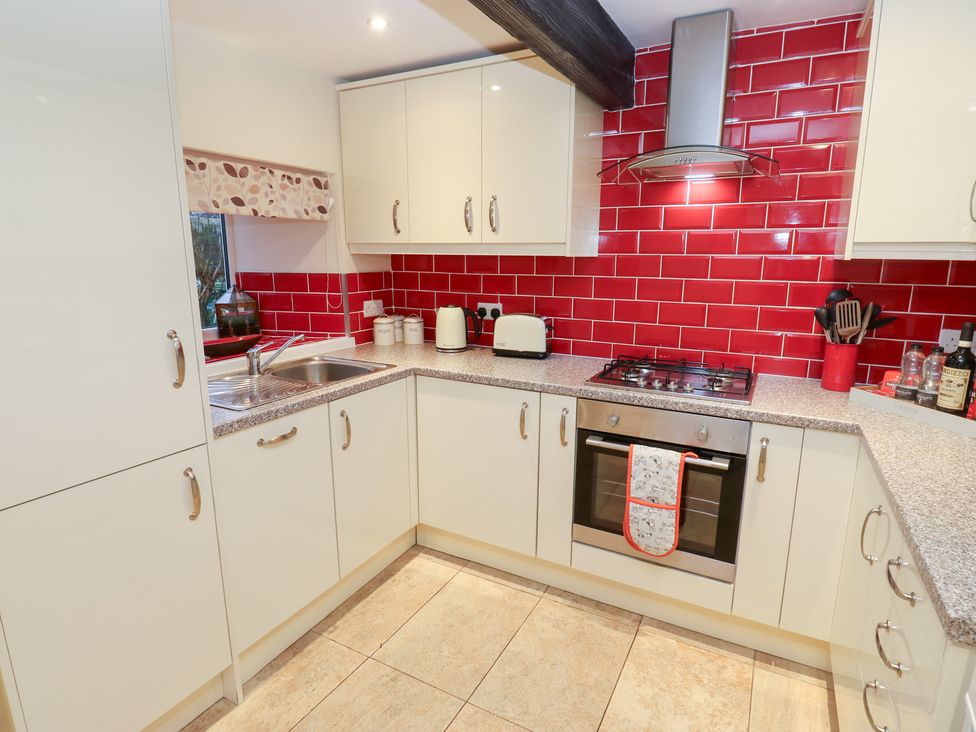 A kitchen with a sink and gas stove at Rosemount Cottage in Barnoldswick