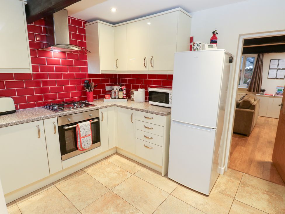 A kitchen with appliances and cabinets at Rosemount Cottage in Barnoldswick