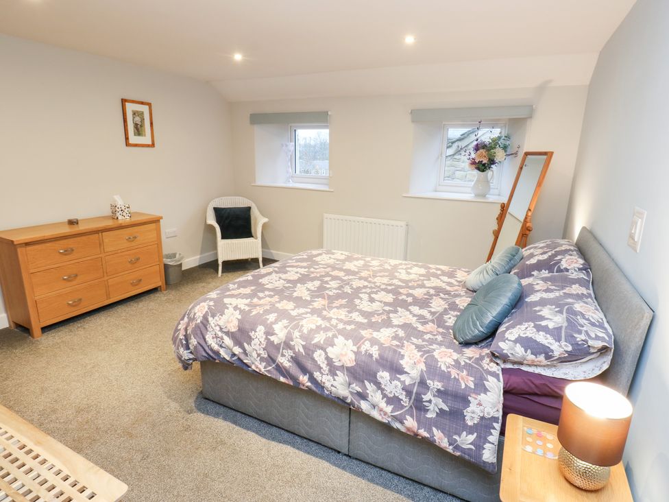 A bedroom with a bed and furniture at Rosemount Cottage in Barnoldswick