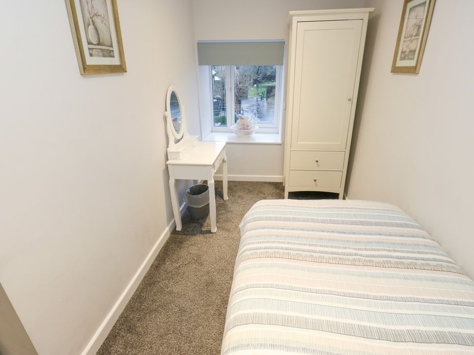 A bedroom with a bed and desk at Rosemount Cottage in Barnoldswick