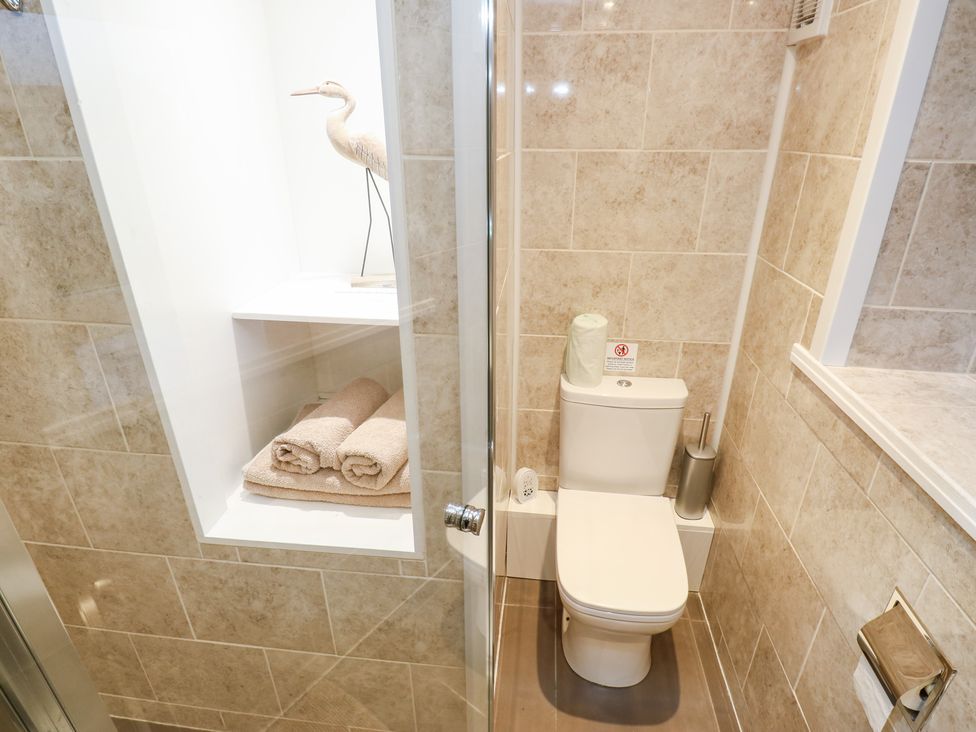 A bathroom with a toilet and towels displayed at Rosemount Cottage Barnoldswick