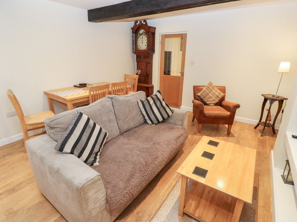 A living room with a sofa and dining area at Rosemount Cottage Barnoldswick