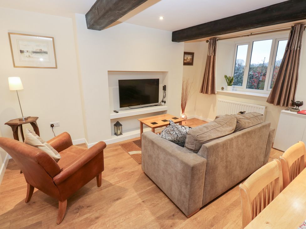 A living room with a television and sofa at Rosemount Cottage Barnoldswick