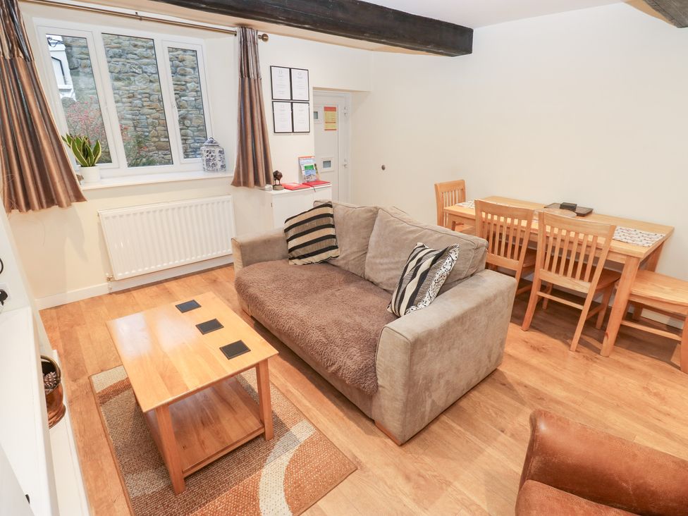 A living room with a couch and dining table at Rosemount Cottage in Barnoldswick