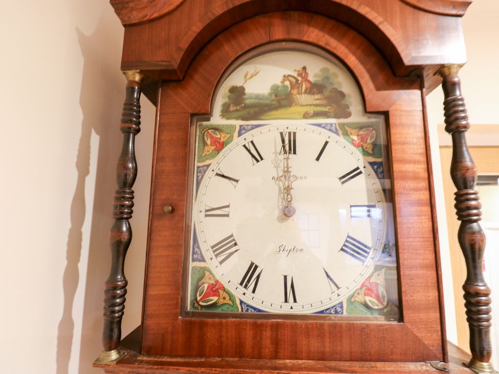 A grandfather clock with a decorative face at Rosemount Cottage Barnoldswick