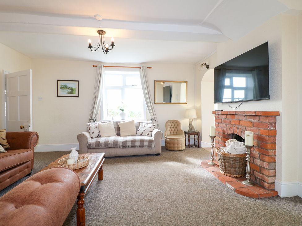 A living room with a sofa and a television at Far Coley Farm and Kilnhurst Log Cabin Great Haywood