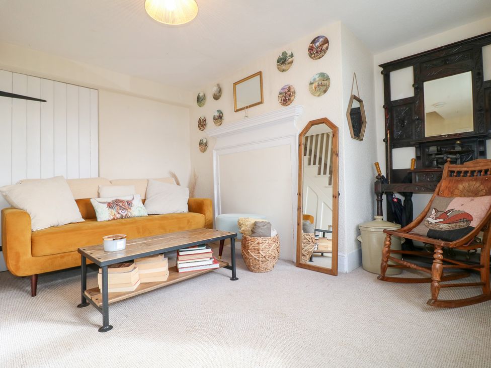 A living room with a sofa, coffee table, and rocking chair at Far Coley Farm and Kilnhurst Log Cabin in Great Haywood