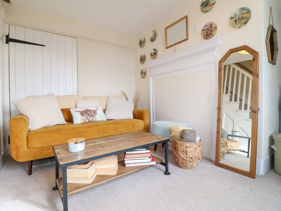 A living room with a sofa, coffee table, and mirror at Far Coley Farm and Kilnhurst Log Cabin Great Haywood