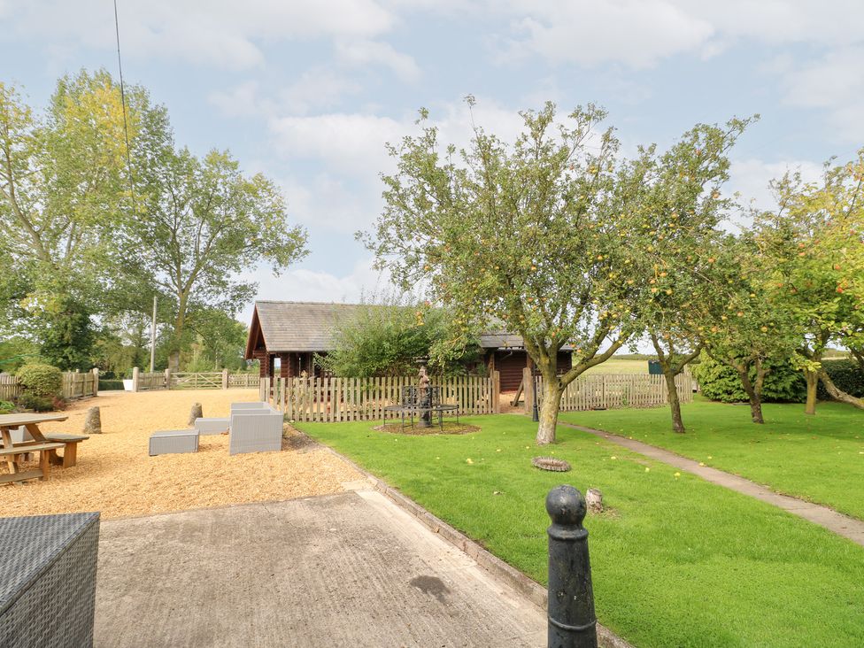 A garden with a log cabin and trees at Far Coley Farm and Kilnhurst Log Cabin Great Haywood