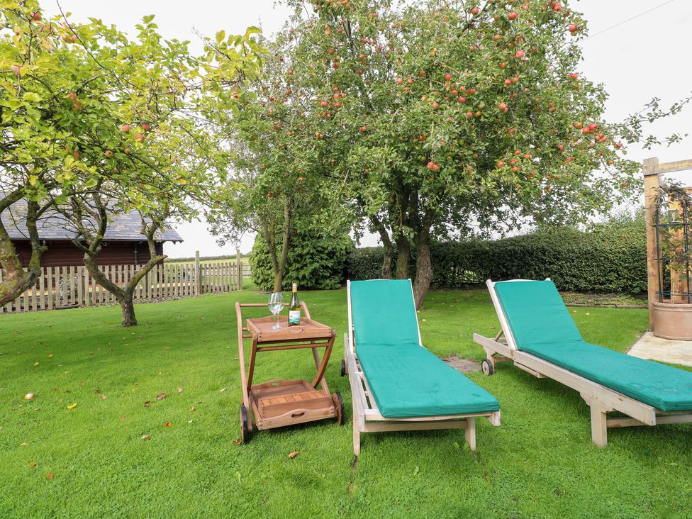 A garden with two loungers and a table at Far Coley Farm and Kilnhurst Log Cabin in Great Haywood