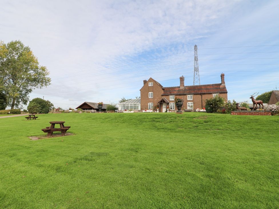 A house with garden and benches at Far Coley Farm and Kilnhurst Log Cabin in Great Haywood