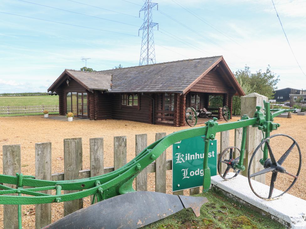 An outdoor view of Kilnhurst Lodge with a plough sign at Far Coley Farm and Kilnhurst Log Cabin in Great Haywood