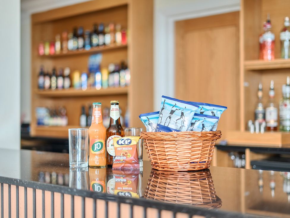 A kitchen countertop with beverages and snacks in a basket at Marine Court Three Bedroom Second-floor Apartment 32 Littlehampton