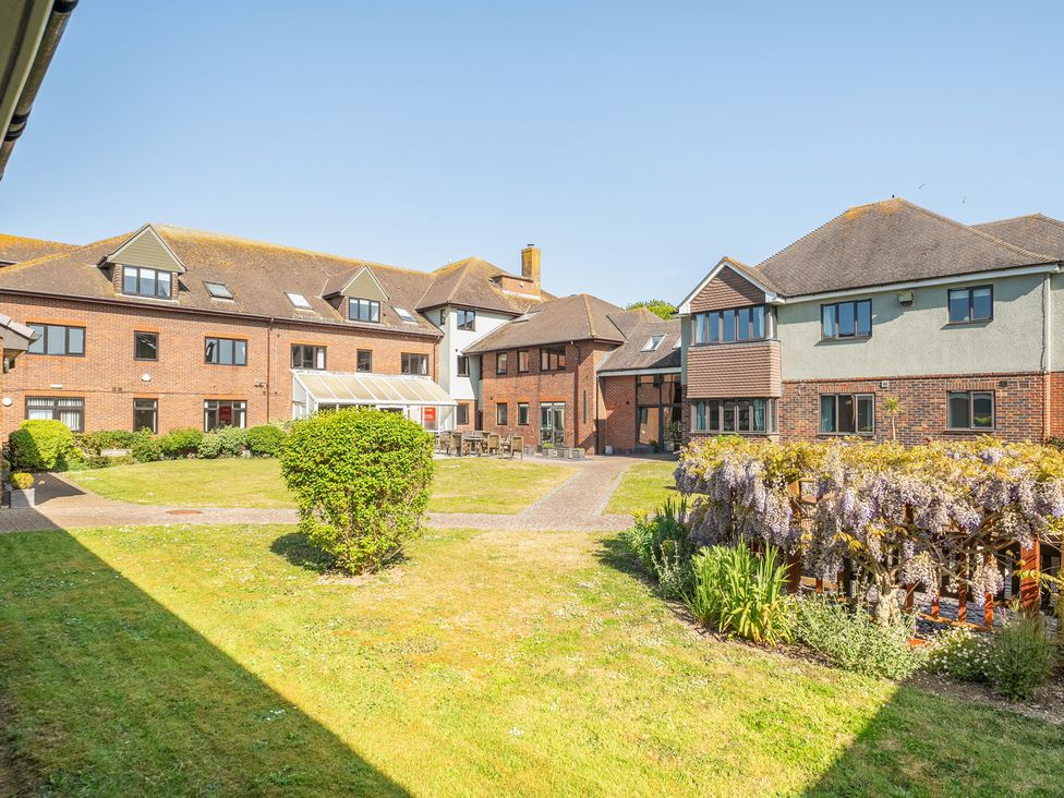 A courtyard with buildings and seating areas at Marine Court Three Bedroom Second-floor Apartment 34 in Littlehampton