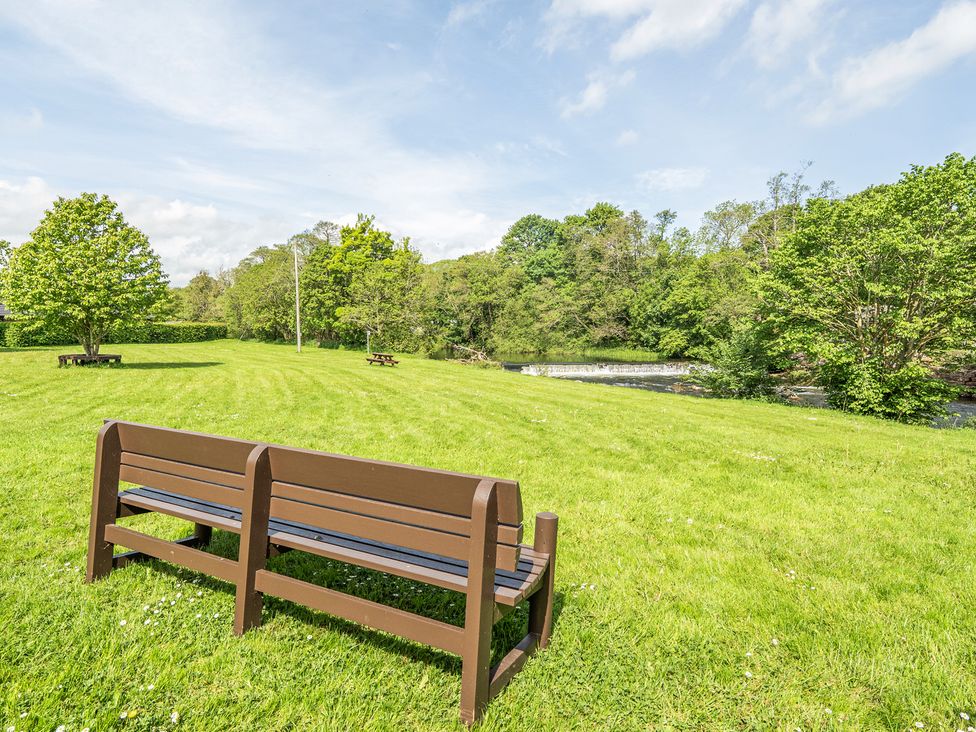 A park with a bench and trees near a river at Jubilee Two Bedroom House Pet Friendly Penrith