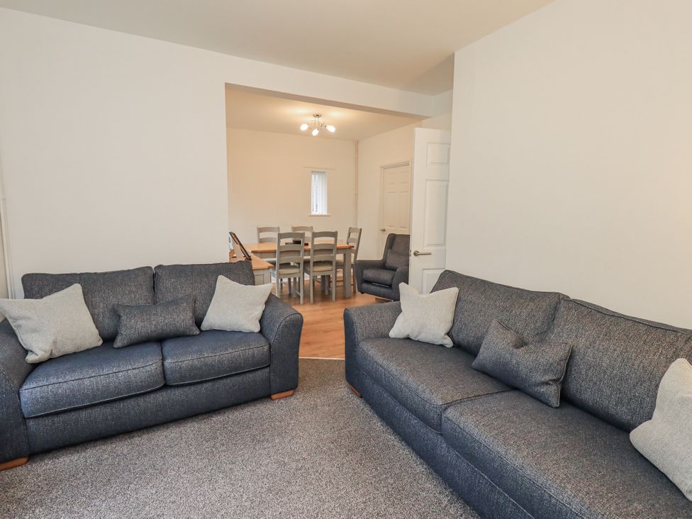 A living room with sofas and a dining area at 1 Eamont Park in Penrith