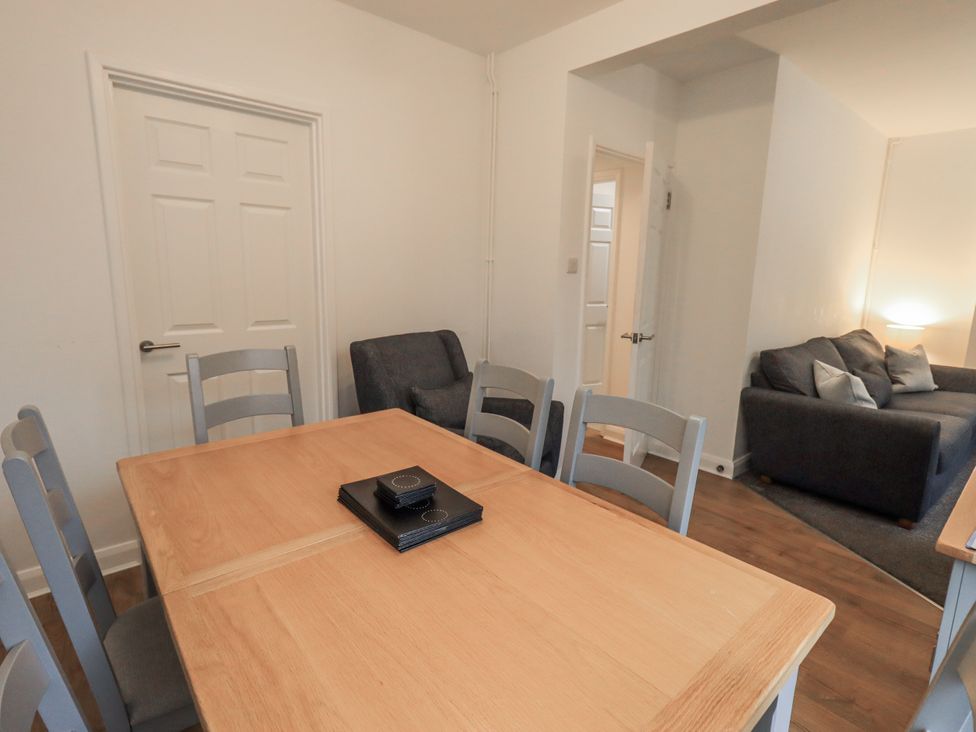 A dining room with a wooden table and chairs at 1 Eamont Park Penrith