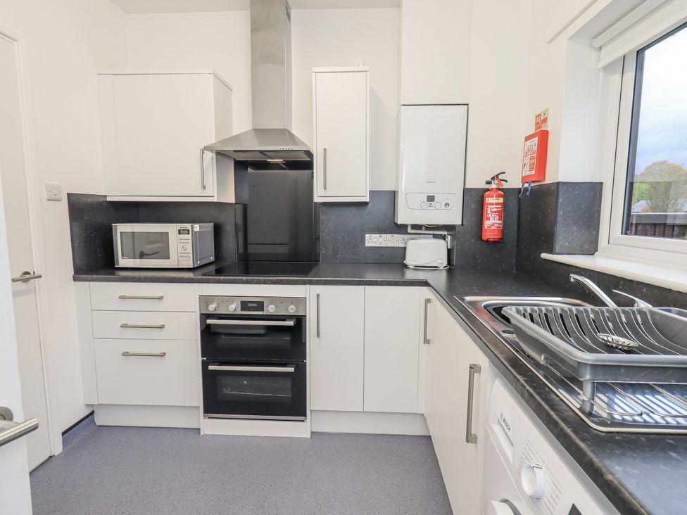 A kitchen with appliances and cabinets at 1 Eamont Park Penrith