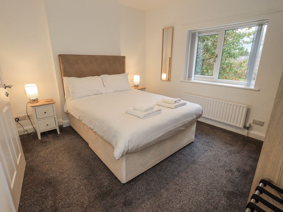 A bedroom with a bed and nightstand at 1 Eamont Park in Penrith