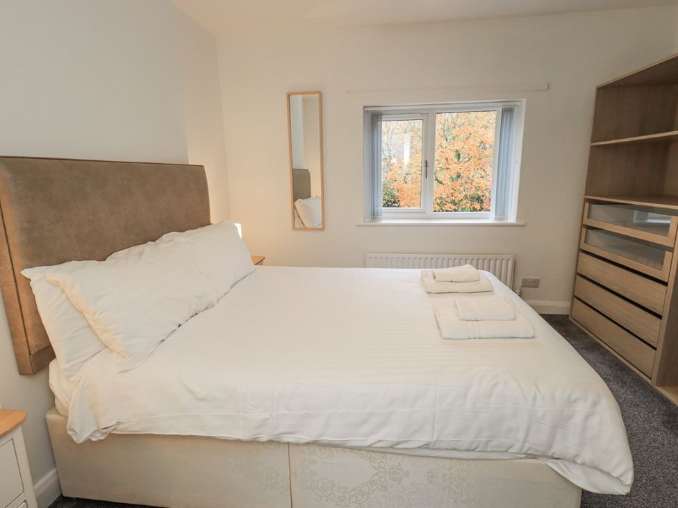 A bedroom with a bed and dresser at 1 Eamont Park in Penrith