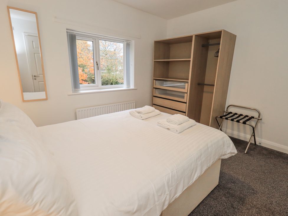 A bedroom with a bed and wardrobe at 1 Eamont Park in Penrith