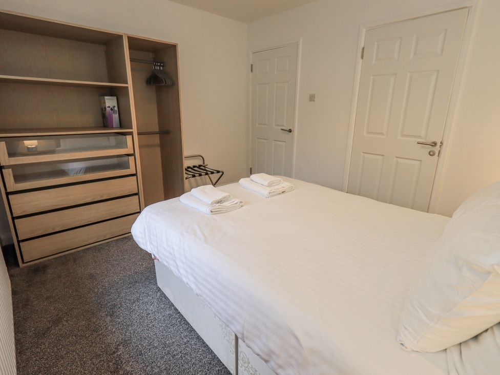 A bedroom with a bed and dresser at 1 Eamont Park in Penrith