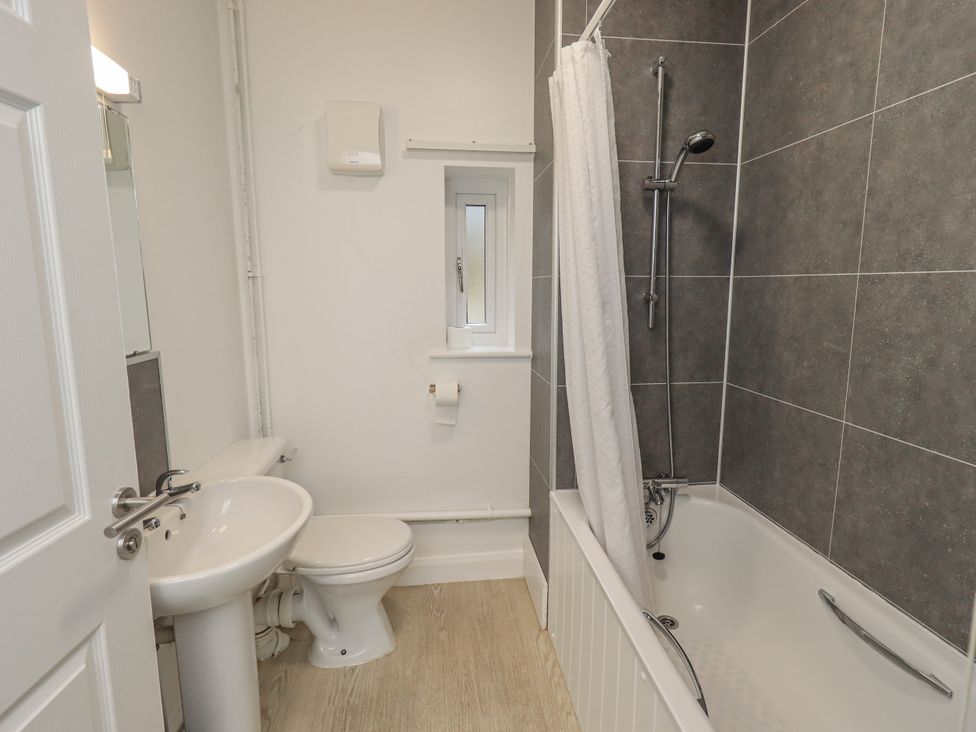 A bathroom with a bath tub, shower, toilet, and sink at 1 Eamont Park, Penrith