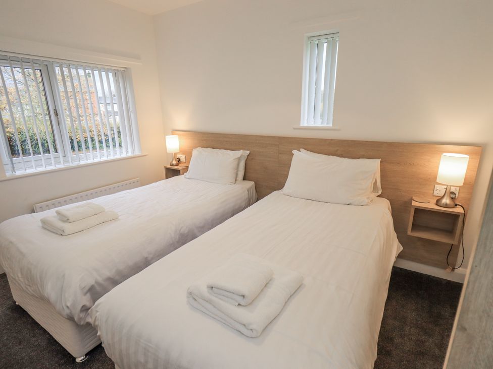 A bedroom with two single beds and a window at 1 Eamont Park Penrith