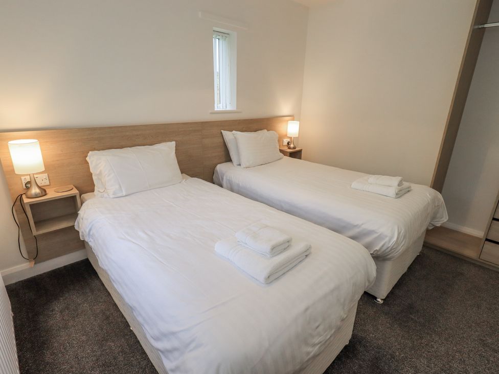 A bedroom with twin beds and a lamp at 1 Eamont Park Penrith