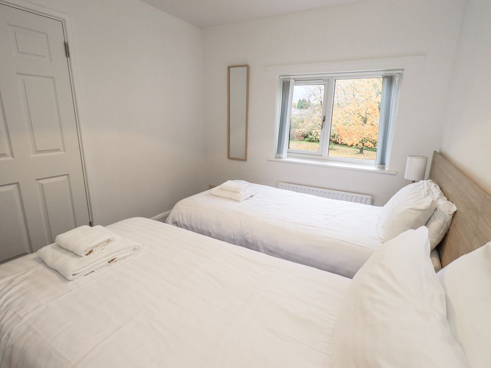 A bedroom with two beds and a window at 1 Eamont Park Penrith