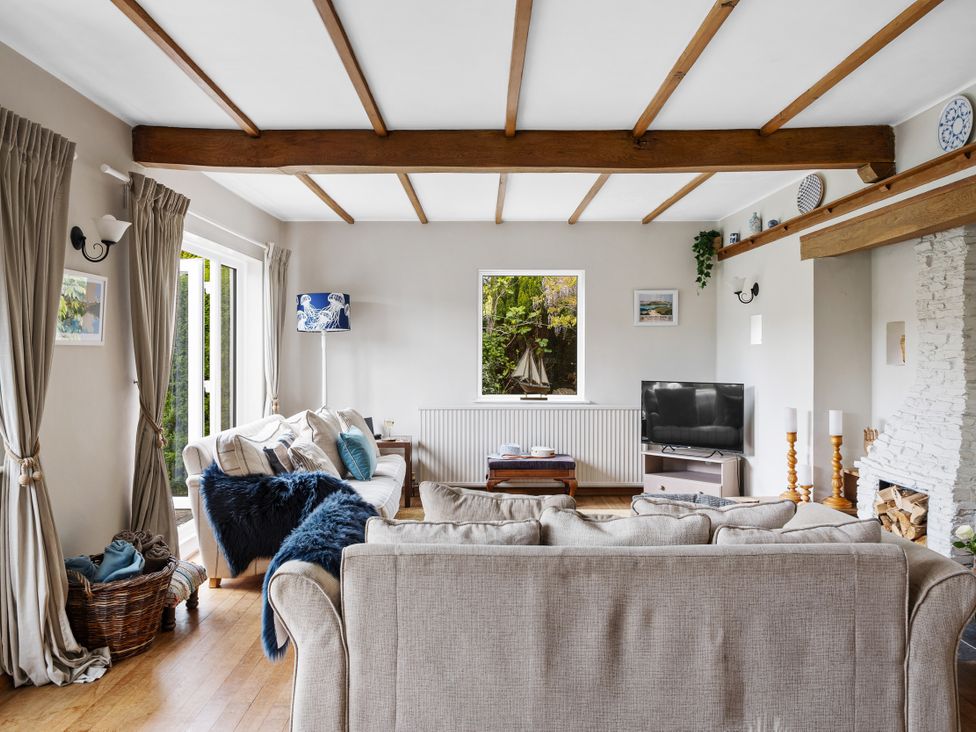 A living room with a sofa and television at 7 Duporth Bay in St. Austell