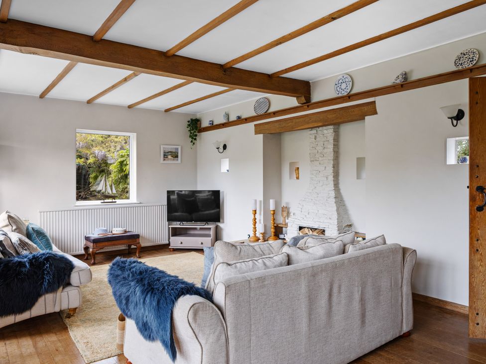A living room with a sofa and television at 7 Duporth Bay in St. Austell