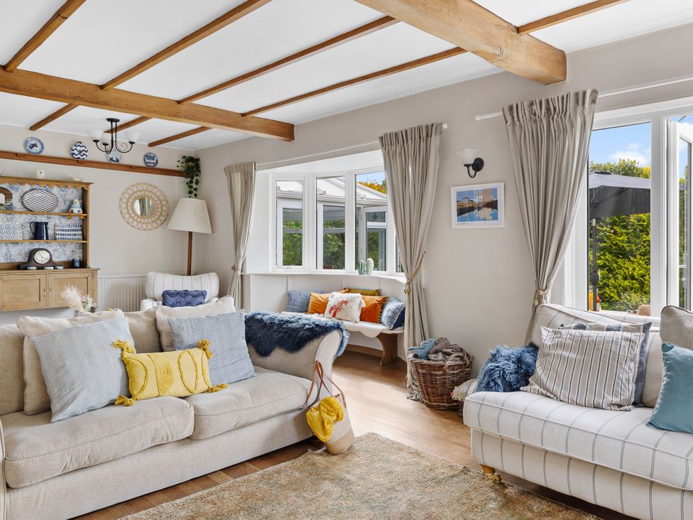 A living room with sofas and a table at 7 Duporth Bay St. Austell