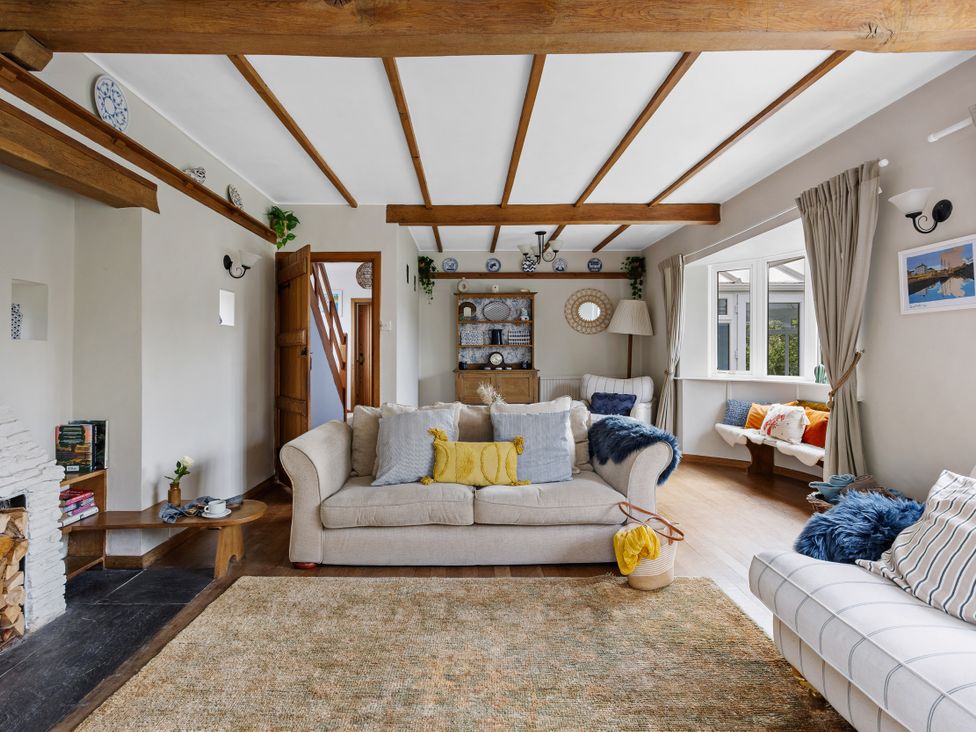 A living room with a sofa and bookshelves at 7 Duporth Bay in St. Austell
