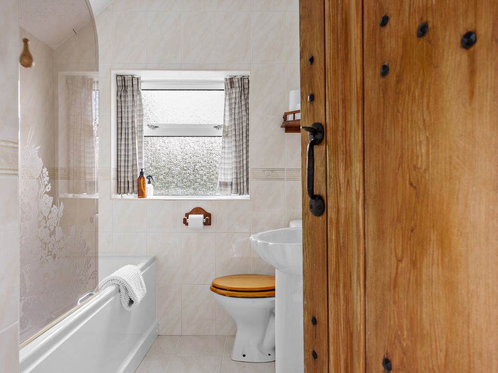 A bathroom with a bathtub and a sink at 7 Duporth Bay in St. Austell