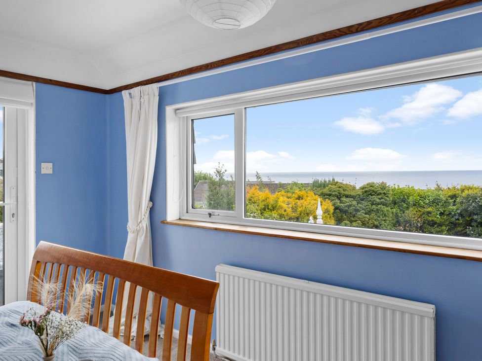 A dining room with a view of the sea at 7 Duporth Bay in St. Austell